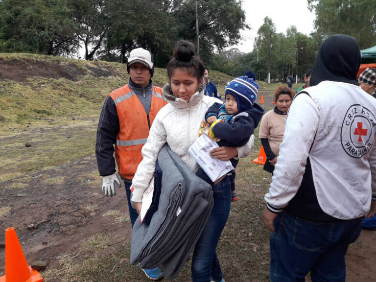 mother and child with thermal blankets in Paraguay flooding 2019
