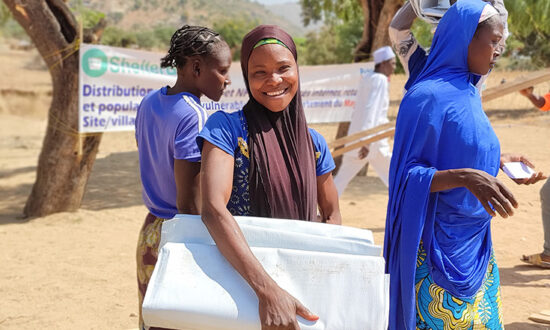 Woman smiling while holding aid in Cameroon