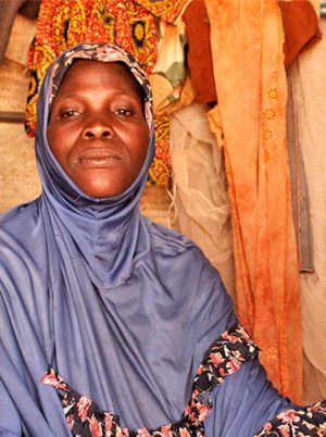 Woman wearing light blue headscarf in a shelter in Burkina Faso