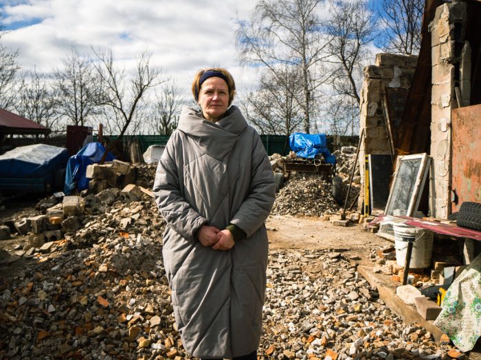 Women standing in remains of destroyed home in Ukraine