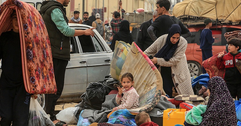 People holding belongings in the street in Gaza