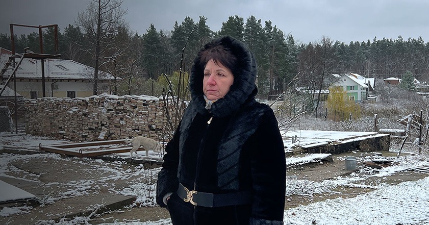 Woman standing in remains of destroyed houses in Ukraine