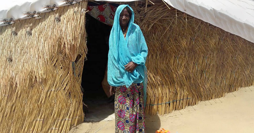 Woman in front of a house in Nigeria