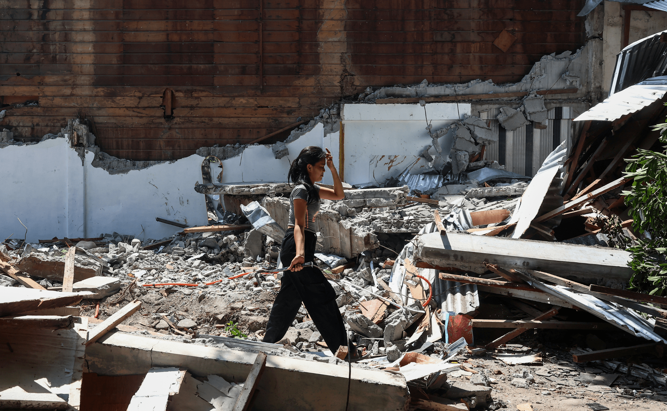 A girl searches for salvageable belongings in the debris of her collapsed home following a deadly earthquake in General Santos, Philippines, on June 10, 2026.